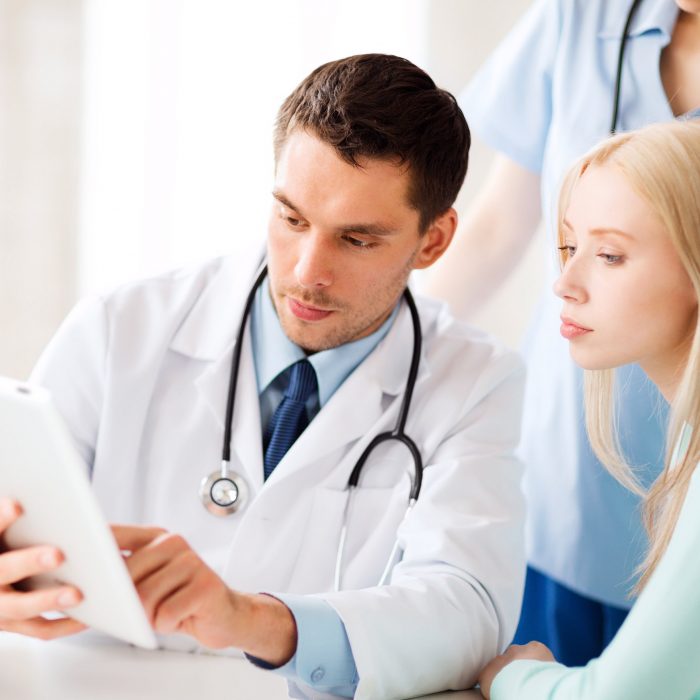 healthcare, medical and technology - doctor showing something patient on tablet pc in hospital